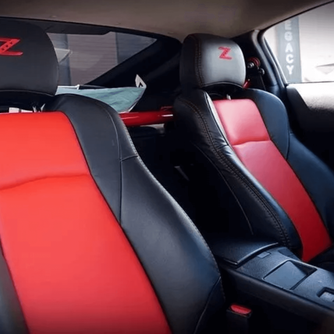 Close-up of red and black leather seat covers for the Nissan 350Z, showing premium stitching and a stylish 'Z' logo on the headrest for the 2003-2008 model.