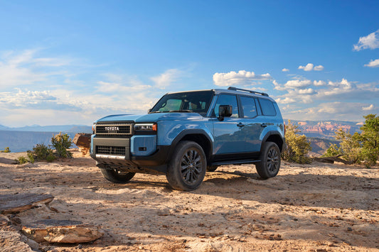 2024 Toyota Land Cruiser driving through rugged terrain, highlighting its new compact design and enhanced off-road capabilities.