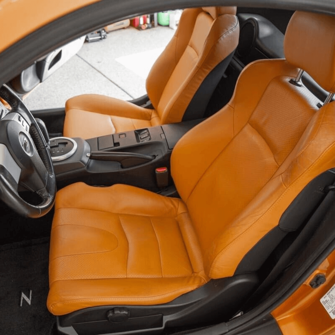 Nissan 350Z synthetic leather seat covers in burnt orange, designed for 2003-2008 models, shown installed in the car, highlighting the vibrant color and snug fit.