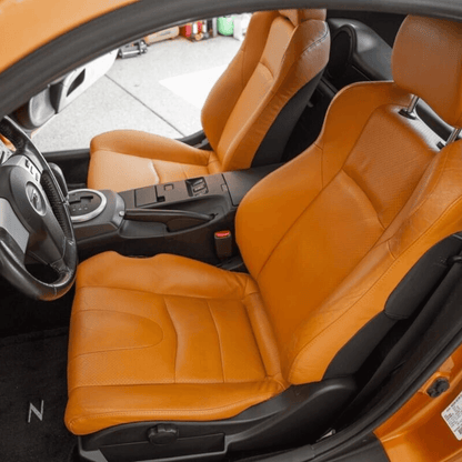 Nissan 350Z synthetic leather seat covers in burnt orange, designed for 2003-2008 models, shown installed in the car, highlighting the vibrant color and snug fit.
