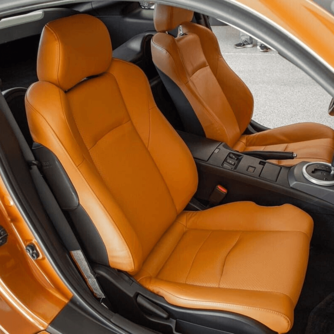 Nissan 350Z synthetic leather seat covers in burnt orange, designed for 2003-2008 models, shown installed in the car, highlighting the vibrant color and snug fit.