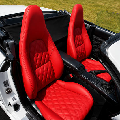 Mazda MX-5 NB Miata (1999–2005) interior featuring custom red leather OEM replacement seat covers with diamond-quilted stitching. Premium sport seats installed in a convertible Miata cabin, showcasing a restored enthusiast-focused interior upgrade.