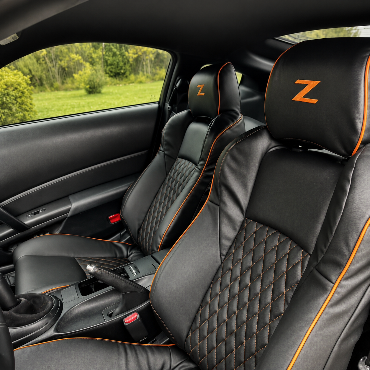 Nissan 350Z black leather seat covers featuring a bold diamond pattern and vibrant orange piping, crafted for 2003-2008 models.
