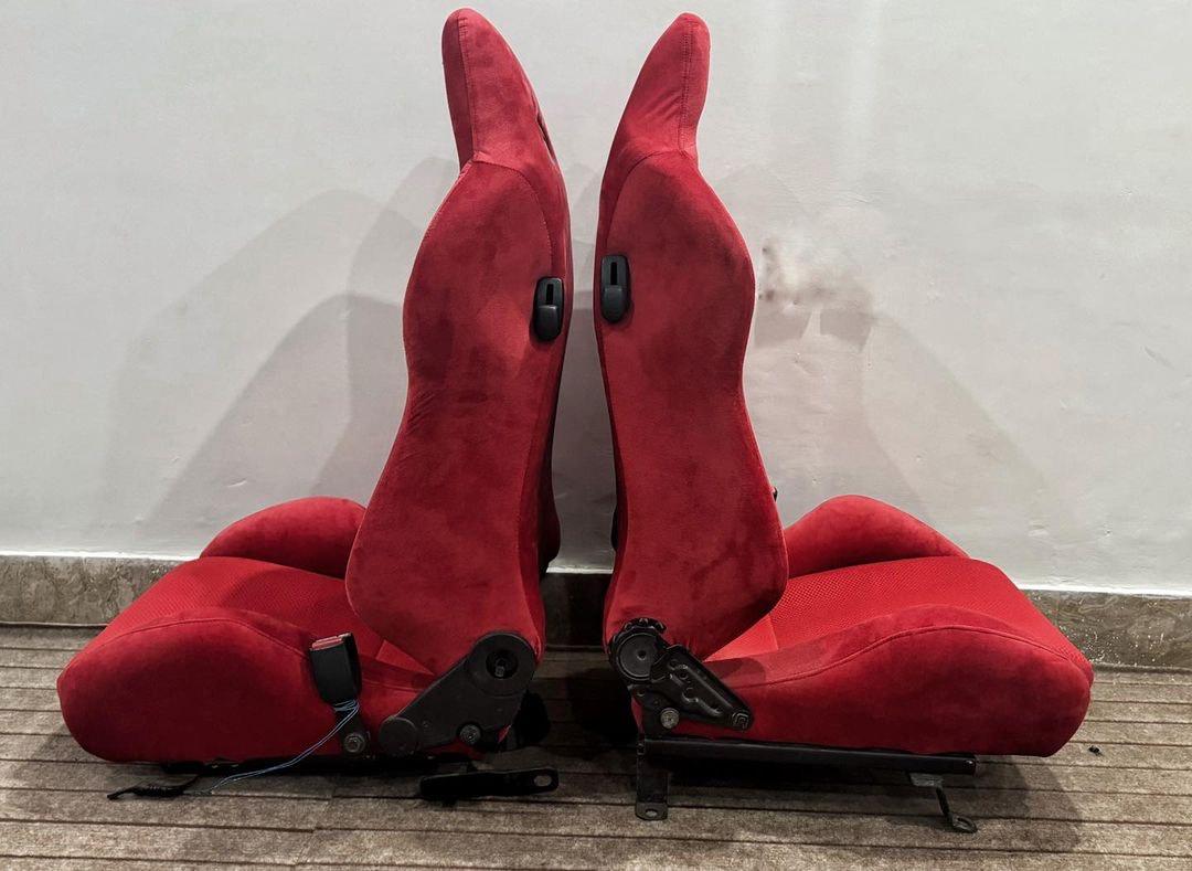 Side-by-side view of Recaro SR3 Confetti DC2 Type R bucket seats in red suede, highlighting the seat profiles and reclining features.