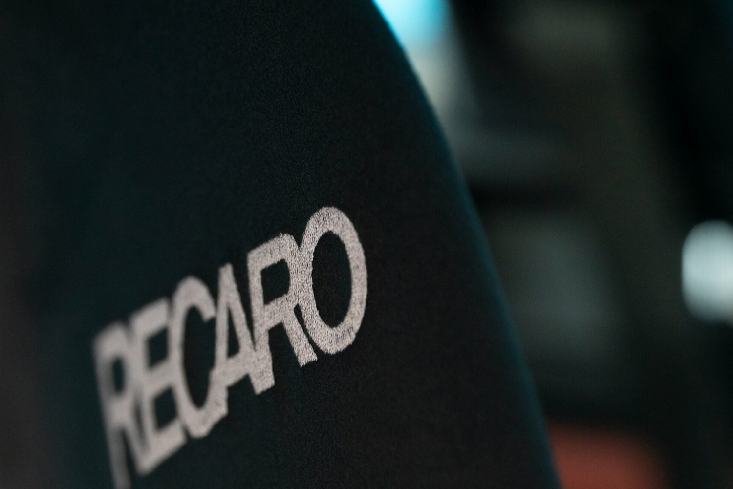 Close-up of the Recaro logo embroidered on the seat backrest, symbolizing quality and performance in automotive seating.